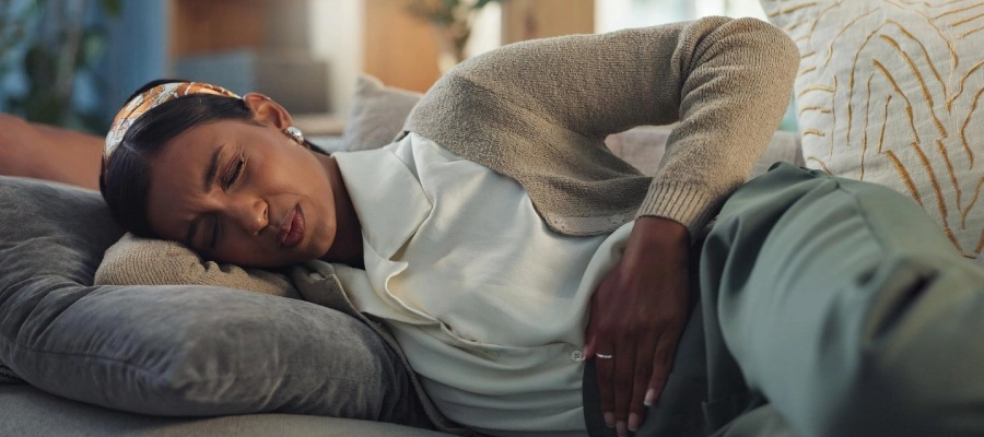 mulher deitada no sofá com virose gastrointestinal