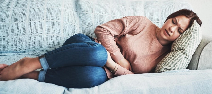 mulher no sofá com suspeita de Gastroenterocolite Aguda (GECA)