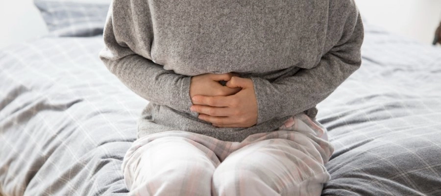 Imagem do post pessoa sentada na cama com as mãos na barriga