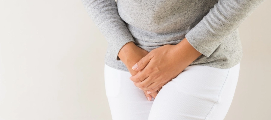 Imagem do post mulher de calça branca com as mãos na região pélvica