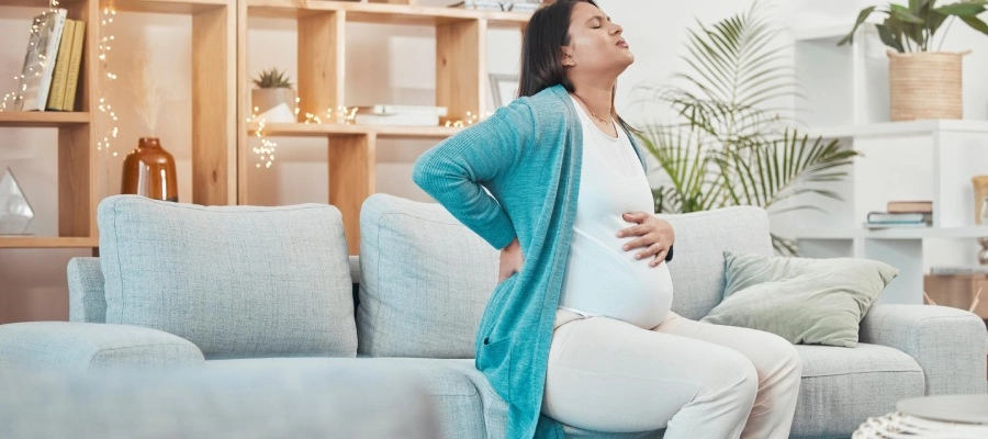 mulher grávida sentada no sofá na sala
