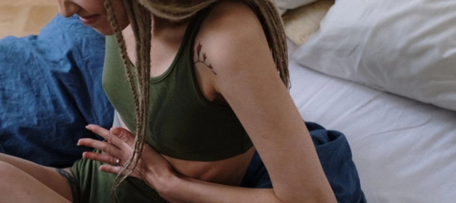 Imagem do post uma mulher de top verde sentada em uma cama