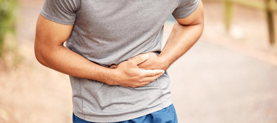 Imagem do post homem de camisa cinza ao ar livre com as mãos na barriga