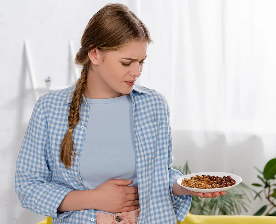 Imagem do post uma mulher segurando um prato de comida e põe a mão na barriga