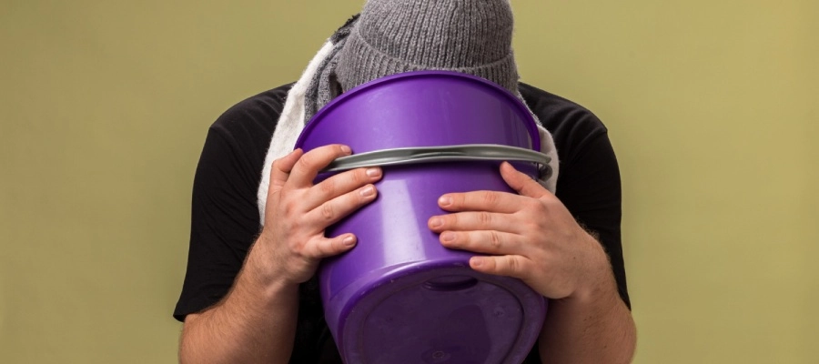 Imagem do post homem vomita em um balde roxo