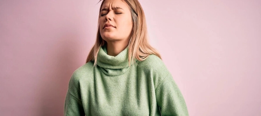 Imagem do post mulher com blusa verde sentindo dor