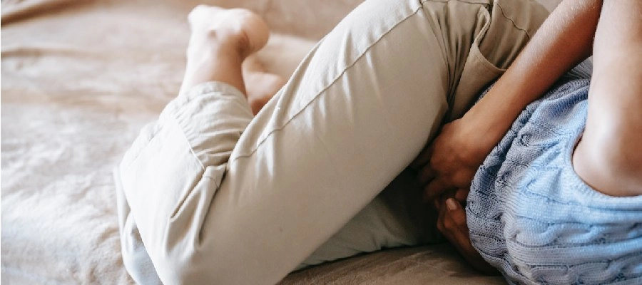 Imagem do post mulher deitada em posição fetal com dor