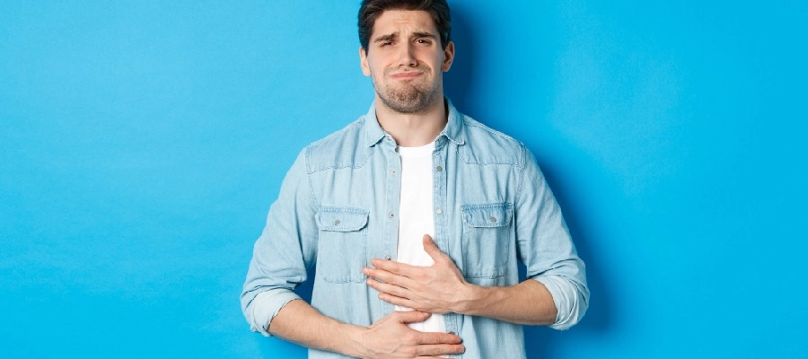 Imagem do post homem com dor no estômago em um fundo azul