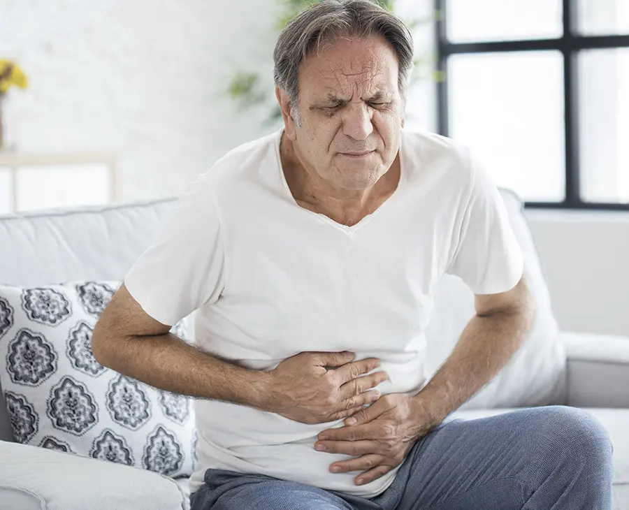 Imagem do post homem mais velho sentado com as duas mãos na barriga