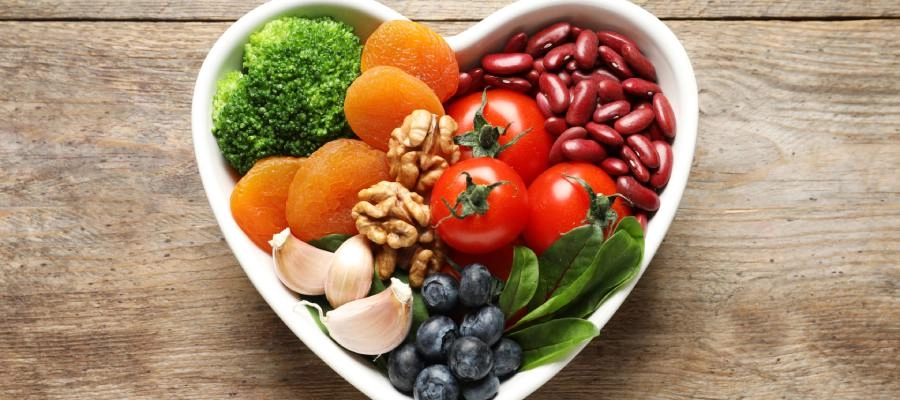 uma tigela em forma de coração cheia de frutas e legumes