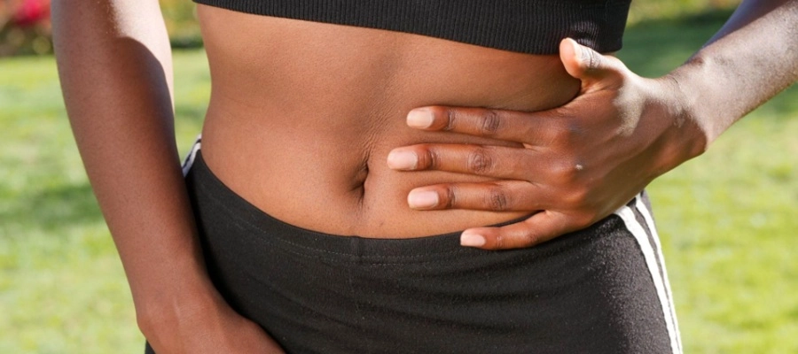 Imagem do post mulher preta com a mão na lateral da barriga