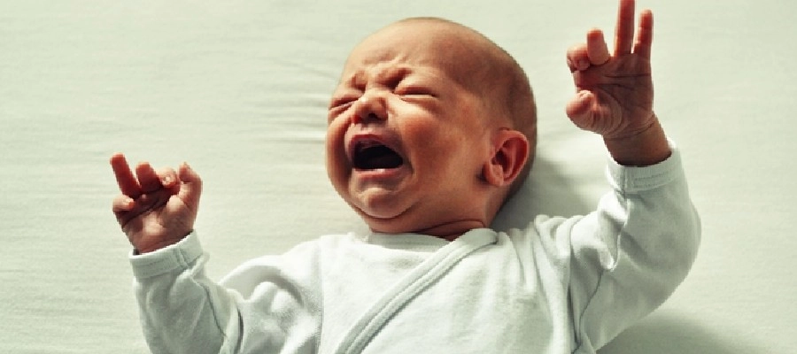 Imagem do post bebê está chorando com as mãos para cima