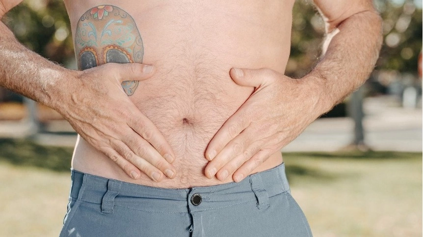 Imagem do post homem tatuado com as mãos na barriga